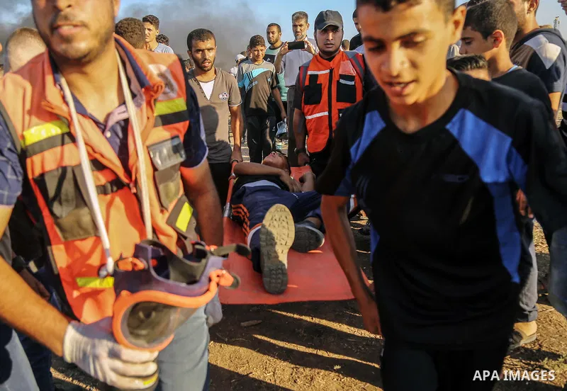 A wounded Palestinian protester is evacuated during clashes with Israeli troops in tents protest where Palestinian demand the right to return to their homeland at the Israel-Gaza border, in east of Gaza City on Aug. 10,...