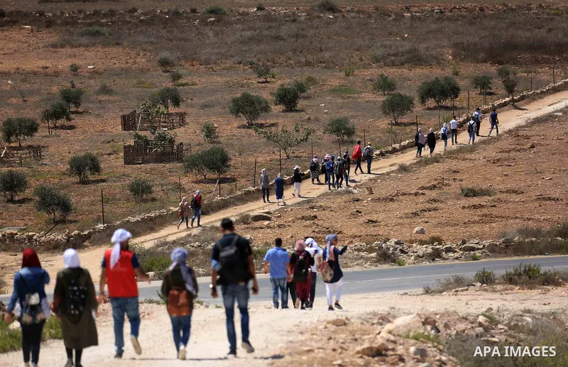 Palestinian youths participate in a tour at Asira al-Shamaliya village near the West Bank city of Nablus on Aug. 10, 2018. Photo by Shadi Jarar'ah