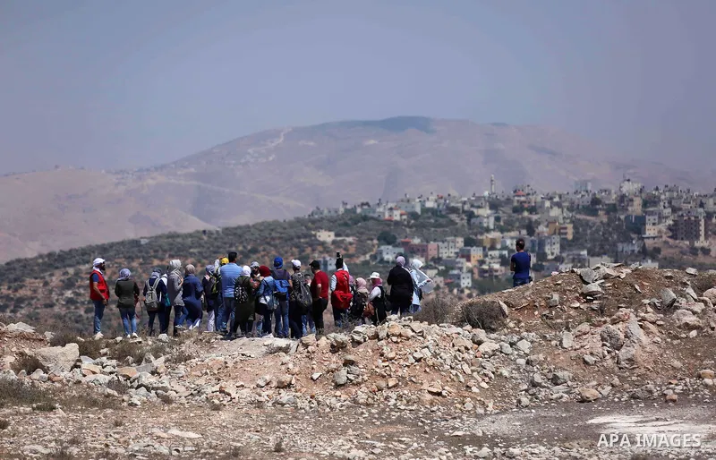 Palestinian youths participate in a tour at Asira al-Shamaliya village near the West Bank city of Nablus on Aug. 10, 2018. Photo by Shadi Jarar'ah