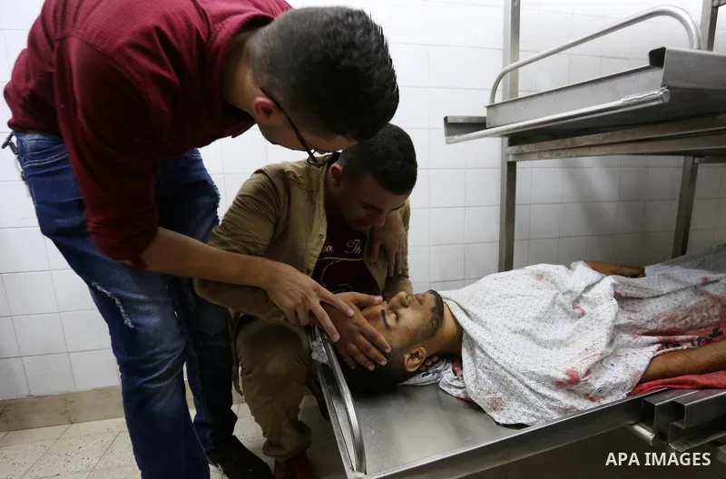 Relatives of Palestinian medic Abdullah Al-Kotati, who was killed by Israeli troops while trying to help wounded protesters during clashes where Palestinians demand the right to return to their homeland at the Israel-Gaz...