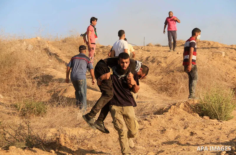 A wounded Palestinian protester is evacuated during clashes with Israeli troops in tents protest where Palestinians demand the right to return to their homeland at the Israel-Gaza border, in Al-Bureij in the center of Ga...