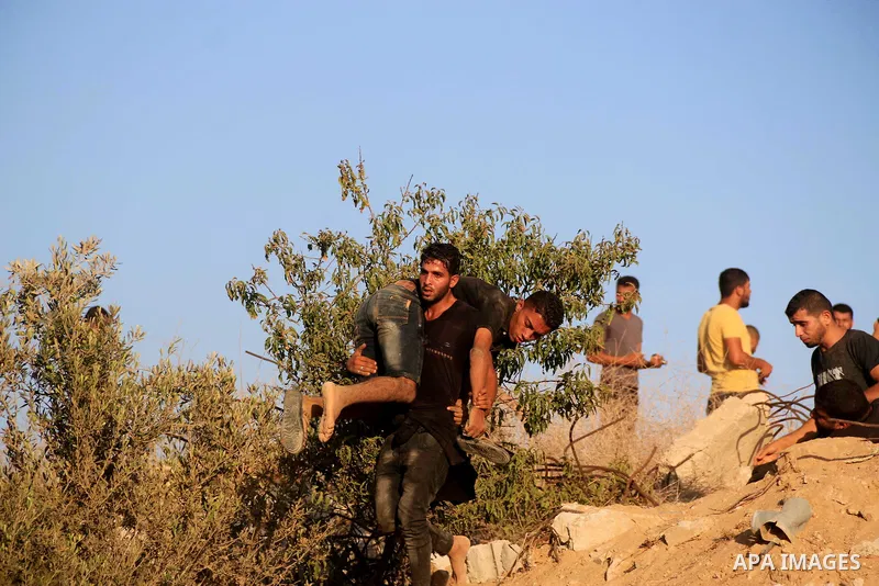 A wounded Palestinian protester is evacuated during clashes with Israeli troops in tents protest where Palestinians demand the right to return to their homeland at the Israel-Gaza border, in Al-Bureij in the center of Ga...