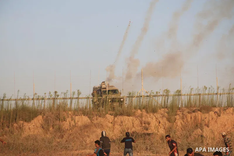 Palestinian protesters gather during clashes with Israeli troops in tents protest where Palestinians demand the right to return to their homeland at the Israel-Gaza border, in Al-Bureij in the center of Gaza Strip on Aug...