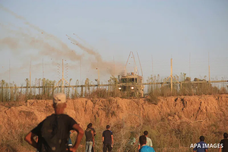 Palestinian protesters gather during clashes with Israeli troops in tents protest where Palestinians demand the right to return to their homeland at the Israel-Gaza border, in Al-Bureij in the center of Gaza Strip on Aug...