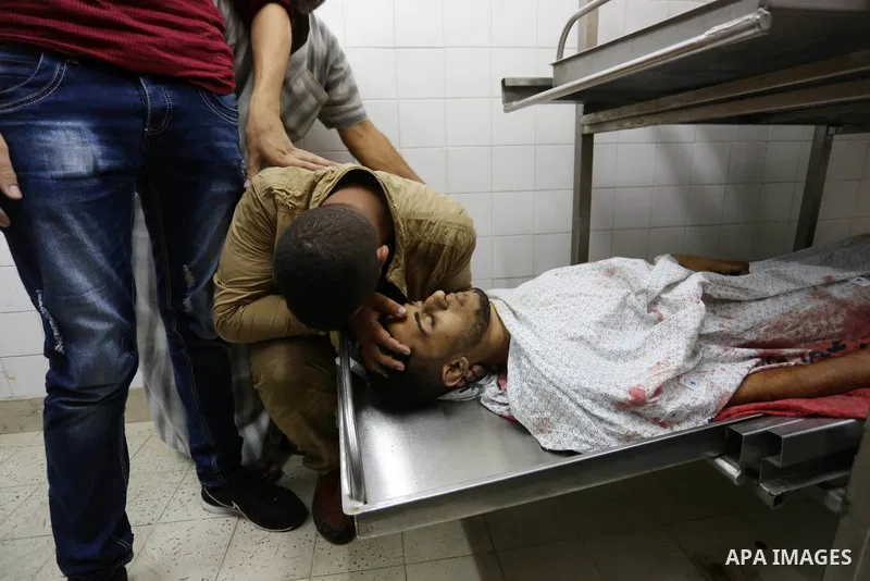 Relatives of Palestinian medic Abdullah Al-Kotati, who was killed by Israeli troops while trying to help wounded protesters during clashes where Palestinians demand the right to return to their homeland at the Israel-Gaz...