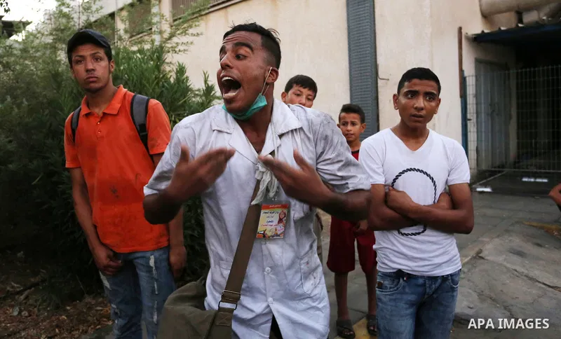 Colleagues of Palestinian medic Abdullah Al-Kotati, who was killed by Israeli troops while trying to help wounded protesters during clashes where Palestinians demand the right to return to their homeland at the Israel-Ga...
