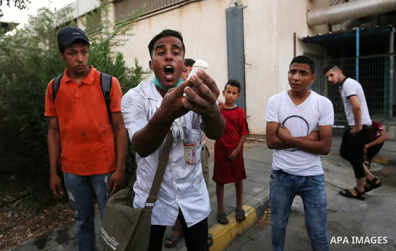 Colleagues of Palestinian medic Abdullah Al-Kotati, who was killed by Israeli troops while trying to help wounded protesters during clashes where Palestinians demand the right to return to their homeland at the Israel-Ga...