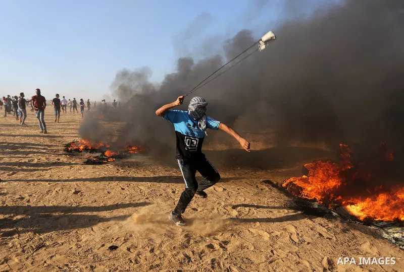 Palestinian protesters gather during clashes with Israeli troops in tents protest where Palestinians demand the right to return to their homeland at the Israel-Gaza border, in Khan Younis in the southern Gaza Strip on Au...