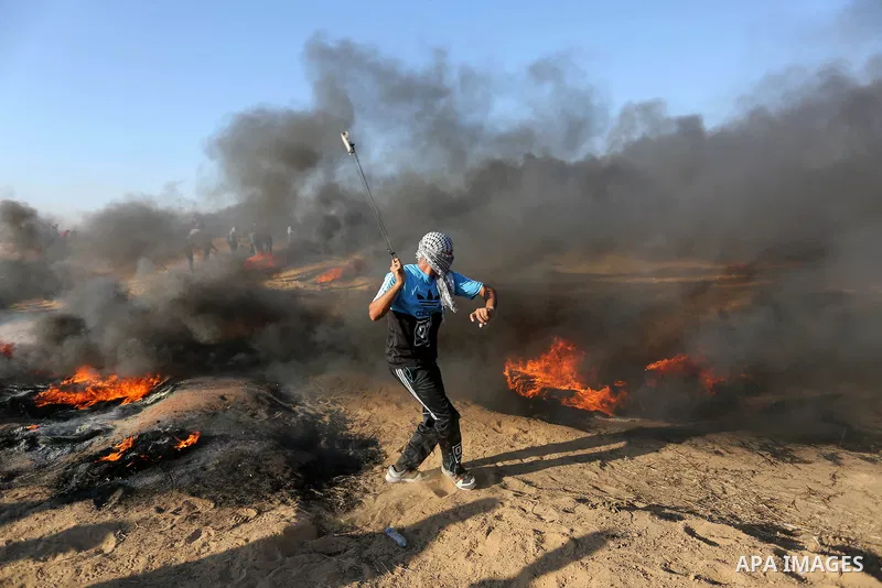 Palestinian protesters gather during clashes with Israeli troops in tents protest where Palestinians demand the right to return to their homeland at the Israel-Gaza border, in Khan Younis in the southern Gaza Strip on Au...