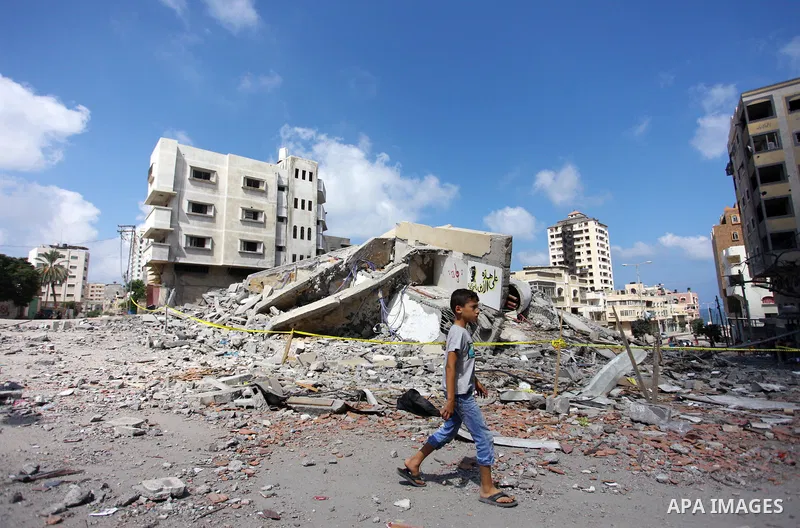 A Palestinian boy walks next to the rubble of Said al-Mishal Cultural Center which was destroyed by an Israeli air strike in Gaza city on Aug. 11, 2018. Photo by Mahmoud Ajour