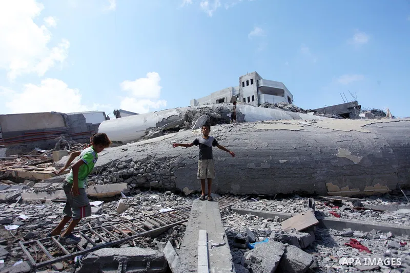 Palestinian children play on the rubble of Said al-Mishal Cultural Center which was destroyed by an Israeli air strike in Gaza city on Aug. 11, 2018. Photo by Mahmoud Ajour
