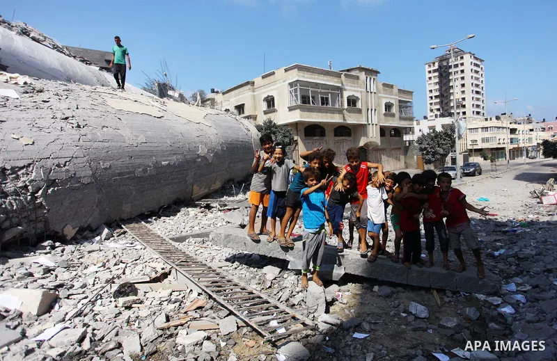 Palestinian children play on the rubble of Said al-Mishal Cultural Center which was destroyed by an Israeli air strike in Gaza city on Aug. 11, 2018. Photo by Mahmoud Ajour