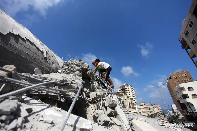 Palestinian children play on the rubble of Said al-Mishal Cultural Center which was destroyed by an Israeli air strike in Gaza city on Aug. 11, 2018. Photo by Mahmoud Ajour