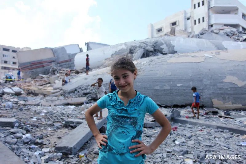 Palestinian children play on the rubble of Said al-Mishal Cultural Center which was destroyed by an Israeli air strike in Gaza city on Aug. 11, 2018. Photo by Mahmoud Ajour