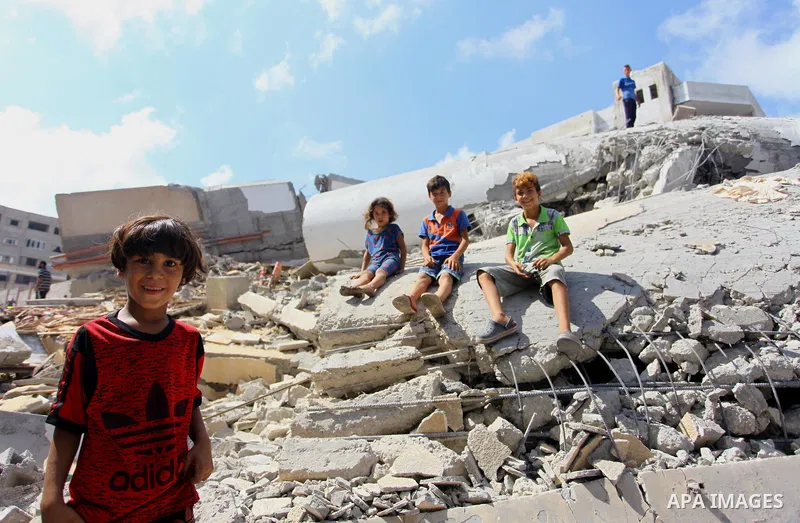 Palestinian children play on the rubble of Said al-Mishal Cultural Center which was destroyed by an Israeli air strike in Gaza city on Aug. 11, 2018. Photo by Mahmoud Ajour