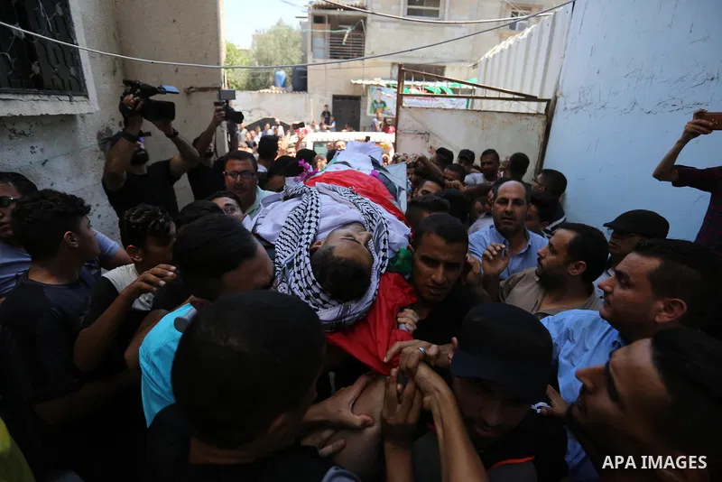 Mourners carry the body of Palestinian volunteer medic Abdullah Al-Kotati, who was killed the day before by Israeli troops while trying to help wounded protesters during clashes where Palestinians demand the right to ret...