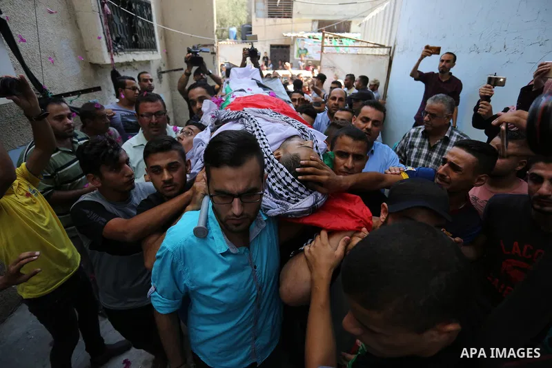 Mourners carry the body of Palestinian volunteer medic Abdullah Al-Kotati, who was killed the day before by Israeli troops while trying to help wounded protesters during clashes where Palestinians demand the right to ret...