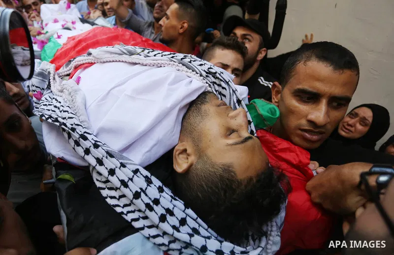 Mourners carry the body of Palestinian volunteer medic Abdullah Al-Kotati, who was killed the day before by Israeli troops while trying to help wounded protesters during clashes where Palestinians demand the right to ret...