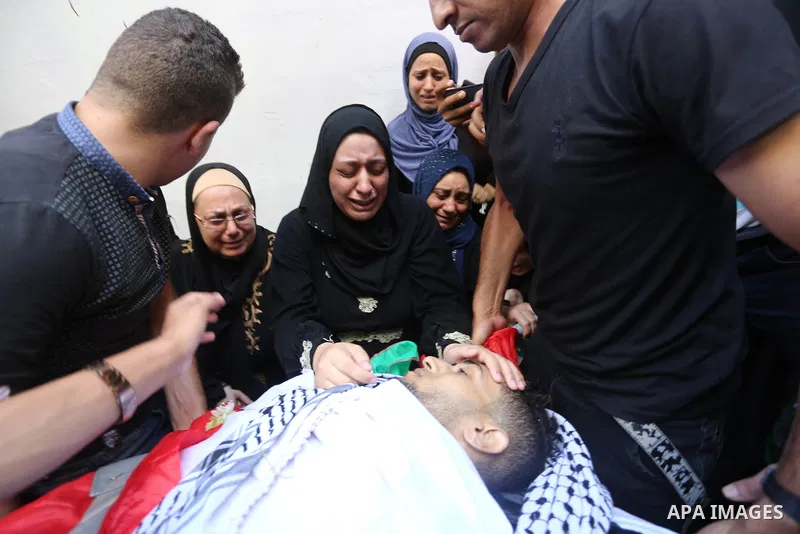 Relatives of Palestinian volunteer medic Abdullah Al-Kotati, who was killed the day before by Israeli troops while trying to help wounded protesters during clashes where Palestinians demand the right to return to their h...