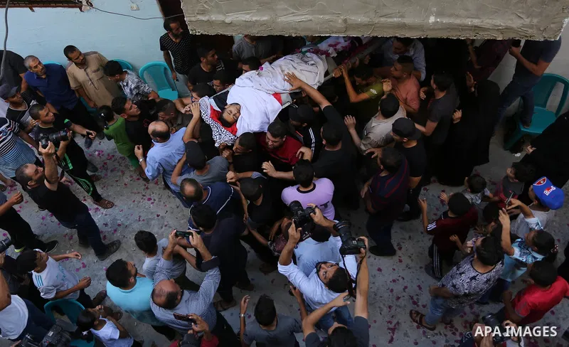 Mourners carry the body of Palestinian volunteer medic Abdullah Al-Kotati, who was killed the day before by Israeli troops while trying to help wounded protesters during clashes where Palestinians demand the right to ret...