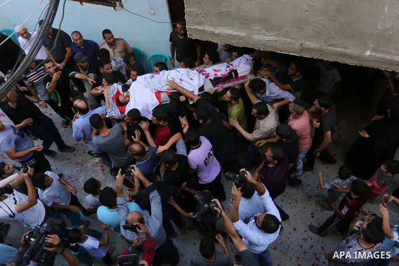 Mourners carry the body of Palestinian volunteer medic Abdullah Al-Kotati, who was killed the day before by Israeli troops while trying to help wounded protesters during clashes where Palestinians demand the right to ret...