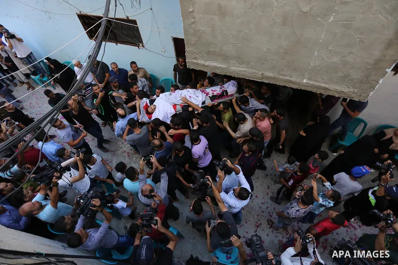 Mourners carry the body of Palestinian volunteer medic Abdullah Al-Kotati, who was killed the day before by Israeli troops while trying to help wounded protesters during clashes where Palestinians demand the right to ret...