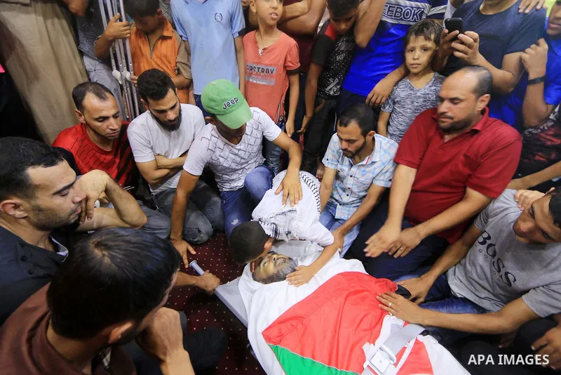Relatives of Palestinian Ali Aloul, 55, who was killed the day before by Israeli troops during clashes where Palestinians demand the right to return to their homeland at the Israel-Gaza border, mourn over of his body dur...
