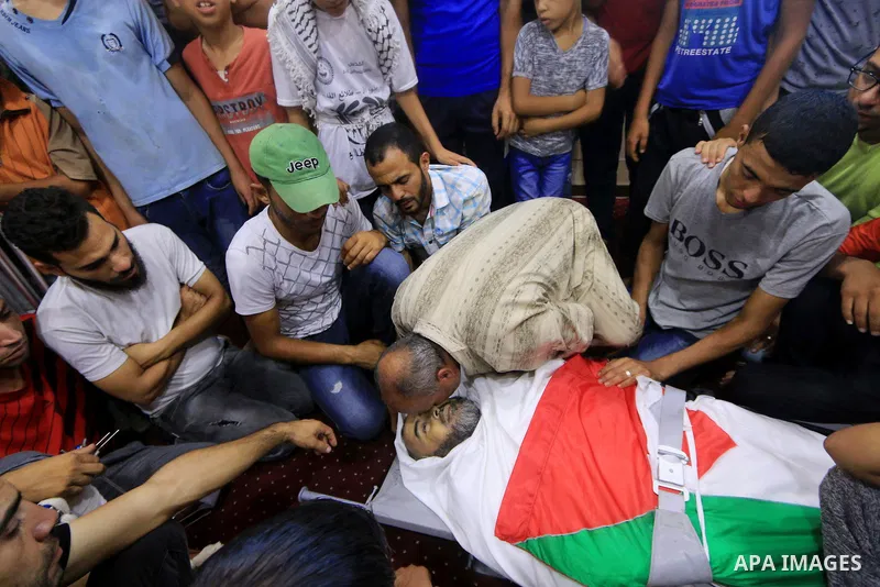 Relatives of Palestinian Ali Aloul, 55, who was killed the day before by Israeli troops during clashes where Palestinians demand the right to return to their homeland at the Israel-Gaza border, mourn over of his body dur...