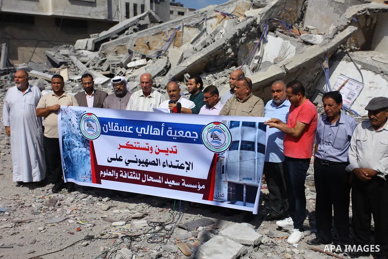 Palestinians take part in a protest against the targeting of Said al-Mishal Cultural Center following an Israeli air strike destroyed it, in Gaza city on August 12, 2018. Photo by Mahmoud Ajour