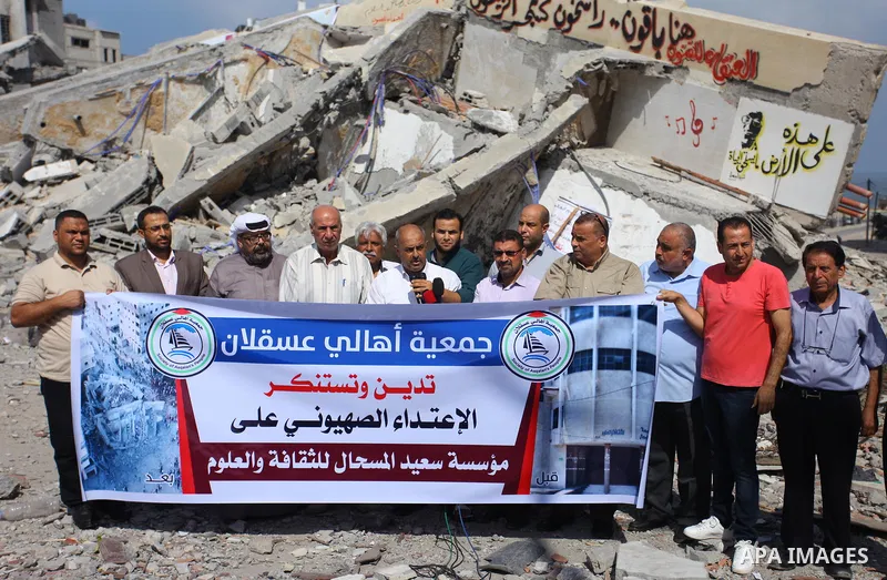 Palestinians take part in a protest against the targeting of Said al-Mishal Cultural Center following an Israeli air strike destroyed it, in Gaza city on August 12, 2018. Photo by Mahmoud Ajour