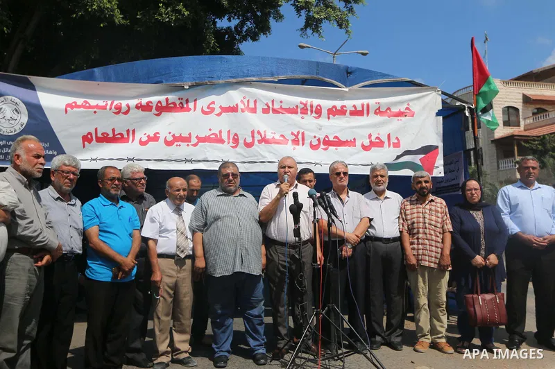 Palestinian members of the National commission for the great return march, attends a press conference, in front of the Council of Ministers headquarter in Gaza City, on August 13, 2018. Photo by Mahmoud Khattab
