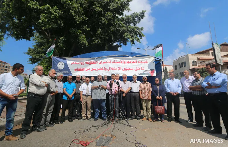 Palestinian members of the National commission for the great return march, attends a press conference, in front of the Council of Ministers headquarter in Gaza City, on August 13, 2018. Photo by Mahmoud Khattab