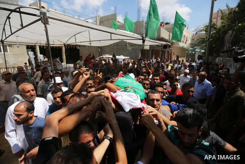 Mourners carry the body of Palestinian Wissam Hijazi, who died of wounds he sustained during clashes with Israeli troops, during his funeral, in Khan Younis in the southern of Gaza Strip on August 13, 2018. Photo by Ashr...