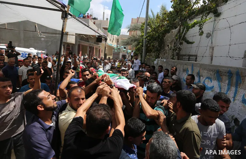 Mourners carry the body of Palestinian Wissam Hijazi, who died of wounds he sustained during clashes with Israeli troops, during his funeral, in Khan Younis in the southern of Gaza Strip on August 13, 2018. Photo by Ashr...