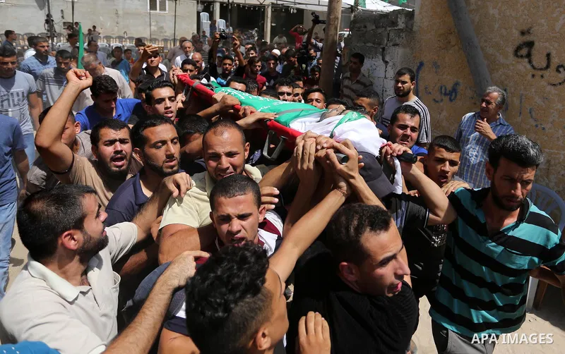 Mourners carry the body of Palestinian Wissam Hijazi, who died of wounds he sustained during clashes with Israeli troops, during his funeral, in Khan Younis in the southern of Gaza Strip on August 13, 2018. Photo by Ashr...