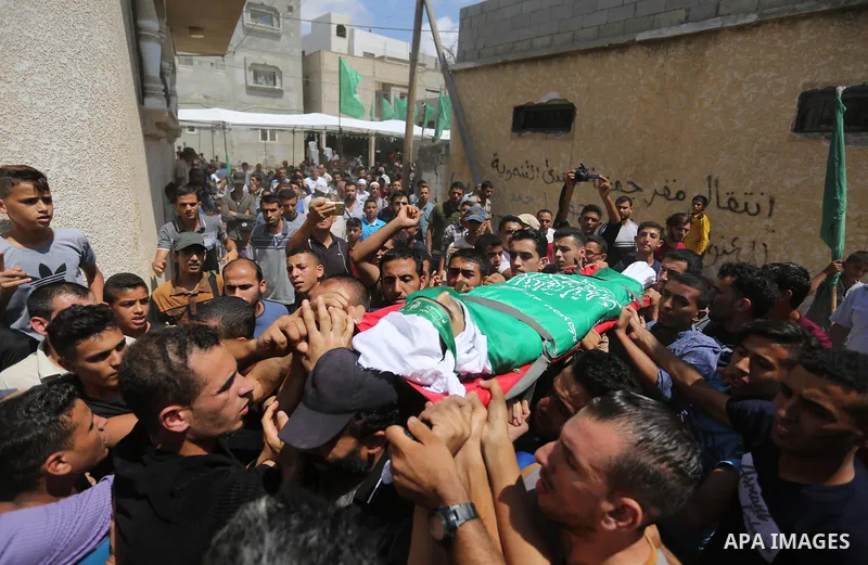 Mourners carry the body of Palestinian Wissam Hijazi, who died of wounds he sustained during clashes with Israeli troops, during his funeral, in Khan Younis in the southern of Gaza Strip on August 13, 2018. Photo by Ashr...