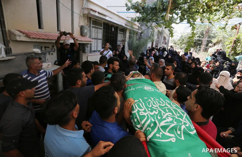 Mourners carry the body of Palestinian Wissam Hijazi, who died of wounds he sustained during clashes with Israeli troops, during his funeral, in Khan Younis in the southern of Gaza Strip on August 13, 2018. Photo by Ashr...