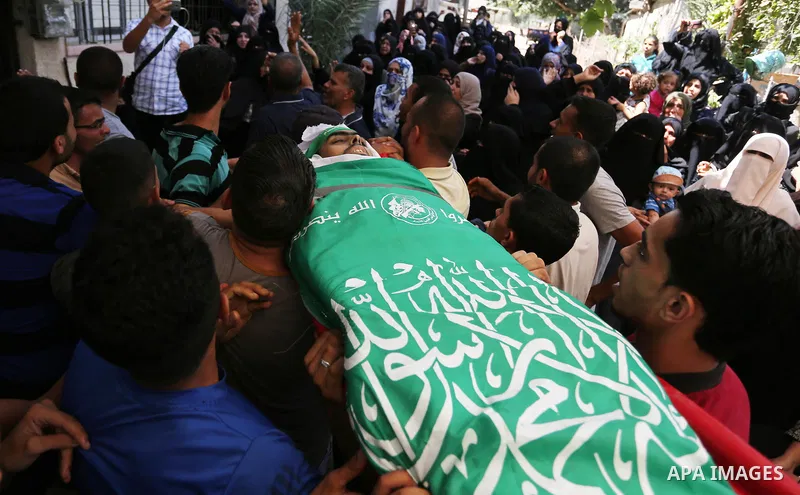 Mourners carry the body of Palestinian Wissam Hijazi, who died of wounds he sustained during clashes with Israeli troops, during his funeral, in Khan Younis in the southern of Gaza Strip on August 13, 2018. Photo by Ashr...