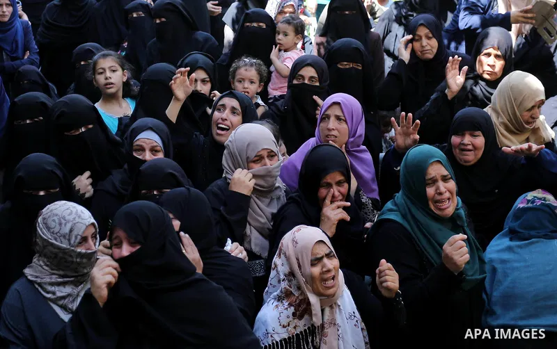 Relatives of Palestinian Wissam Hijazi, who died of wounds he sustained during clashes with Israeli troops, mourn during his funeral, in Khan Younis in the southern of Gaza Strip on August 13, 2018. Photo by Ashraf Amra