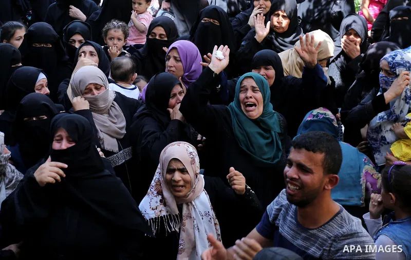Relatives of Palestinian Wissam Hijazi, who died of wounds he sustained during clashes with Israeli troops, mourn during his funeral, in Khan Younis in the southern of Gaza Strip on August 13, 2018. Photo by Ashraf Amra