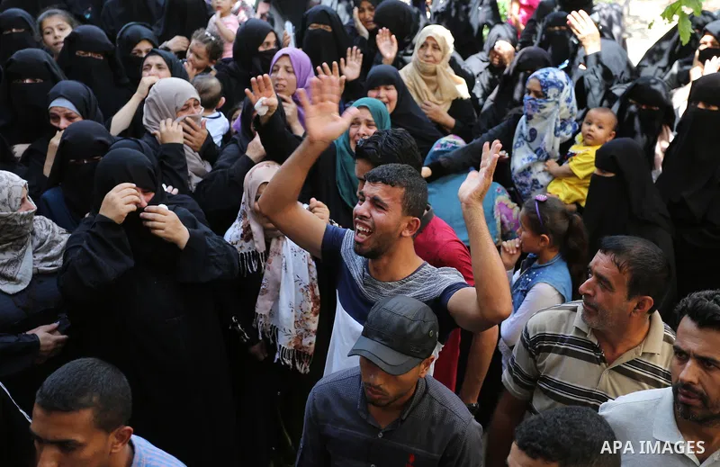 Relatives of Palestinian Wissam Hijazi, who died of wounds he sustained during clashes with Israeli troops, mourn during his funeral, in Khan Younis in the southern of Gaza Strip on August 13, 2018. Photo by Ashraf Amra
