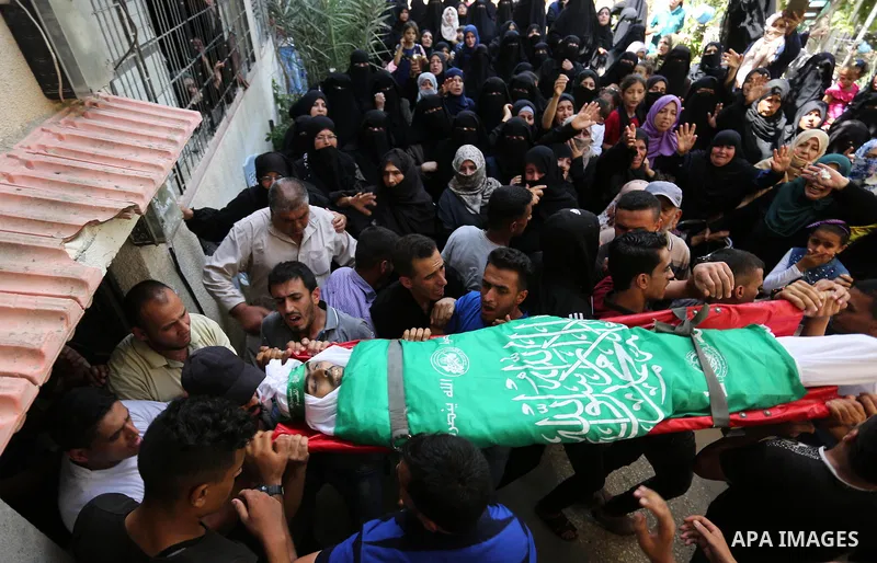Mourners carry the body of Palestinian Wissam Hijazi, who died of wounds he sustained during clashes with Israeli troops, during his funeral, in Khan Younis in the southern of Gaza Strip on August 13, 2018. Photo by Ashr...