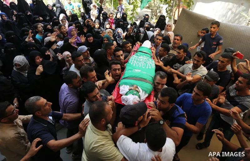 Mourners carry the body of Palestinian Wissam Hijazi, who died of wounds he sustained during clashes with Israeli troops, during his funeral, in Khan Younis in the southern of Gaza Strip on August 13, 2018. Photo by Ashr...