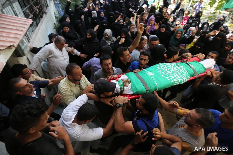 Mourners carry the body of Palestinian Wissam Hijazi, who died of wounds he sustained during clashes with Israeli troops, during his funeral, in Khan Younis in the southern of Gaza Strip on August 13, 2018. Photo by Ashr...