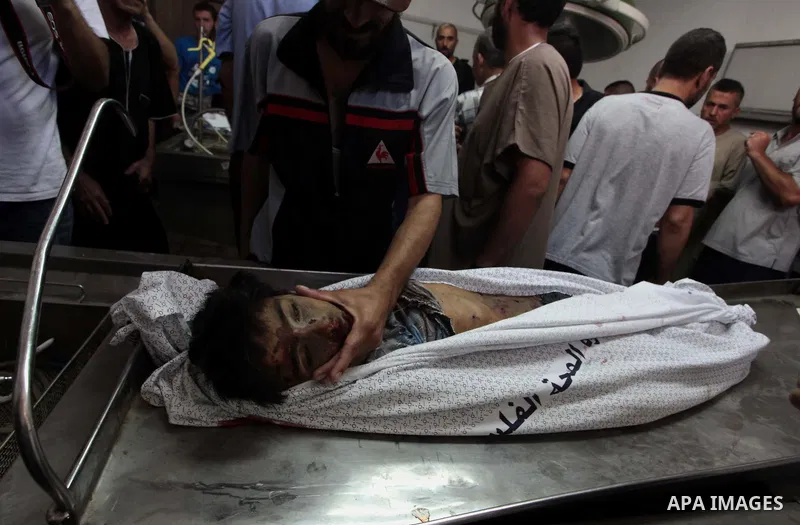 (FILES) This file photo taken on July 16, 2014 shows Relatives of one of four Palestinian children from the Baker family, whom medics said were killed by a shell fired by an Israeli naval gunboat check at the morgue in G...