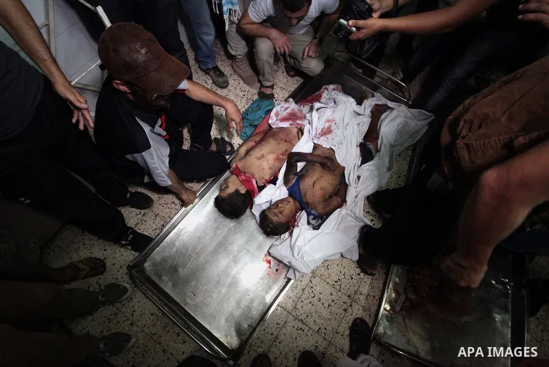 (FILES) This file photo taken on July 16, 2014 shows Relatives of one of four Palestinian children from the Baker family, whom medics said were killed by a shell fired by an Israeli naval gunboat check at the morgue in G...