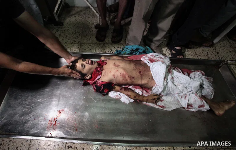 (FILES) This file photo taken on July 16, 2014 shows Relatives of one of four Palestinian children from the Baker family, whom medics said were killed by a shell fired by an Israeli naval gunboat check at the morgue in G...