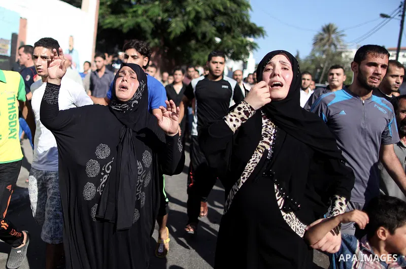 (FILES) This file photo taken on July 16, 2014 shows Relatives of Palestinian children from the Baker family, whom medics said was killed by a shell fired by an Israeli naval gunboat, mourn during their funeral in Gaza C...