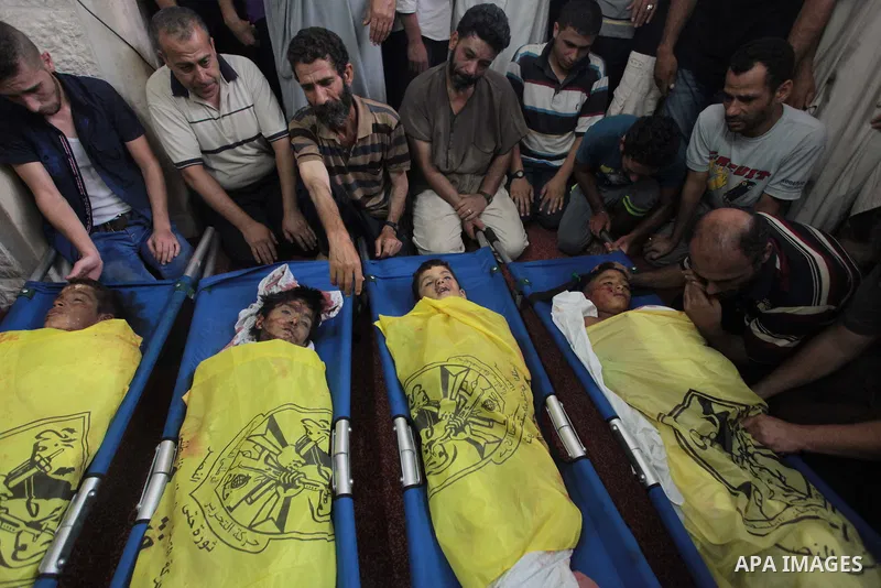 (FILES) This file photo taken on July 16, 2014 shows Palestinians mourn over the body of boys from the Baker family, whom medics said was killed with three other children from the same family by a shell fired by an Israe...