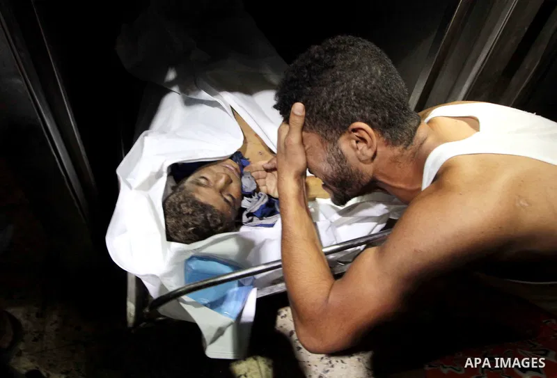 (FILES) This file photo taken on July 16, 2014 shows Relatives of four Palestinian children from the Baker family, whom medics said were killed by a shell fired by an Israeli naval gunboat mourn in the morgue in Gaza Cit...
